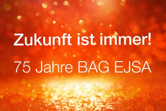 Zukunft ist immer - 75 Jahre BAG EJSA. Glitzer aus orangem Hintergrund